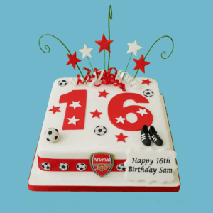 A square football-themed cake decorated in bold red and white colors with contrasting stripes. The cake features small football shapes, star accents, and metallic swirl decorations that add a festive and playful touch. A personalized message plaque is displayed on one side for birthday or celebration greetings. The design combines sporty elements with elegance, making it an eye-catching centerpiece ideal for football fans at milestone birthdays, team events, or sports-themed parties.